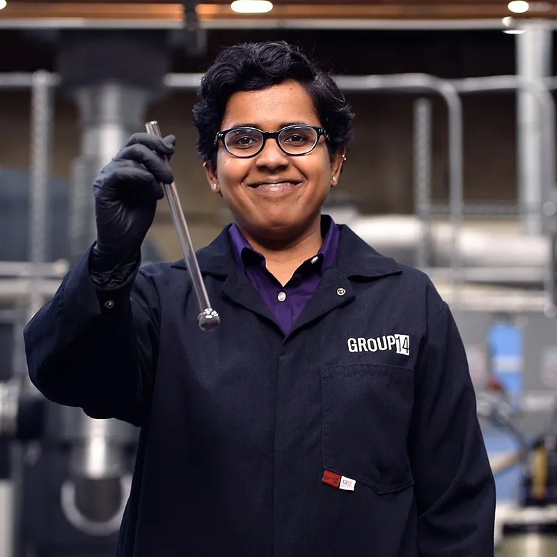 Scientist holds tube of silicon battery material